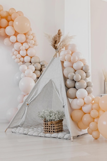 Event decoration in boho style beige balls children’s wigwam