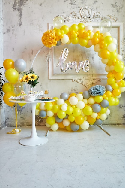 Photo zone of yellow and gray balloons the party is decorated with balloons vertical image
