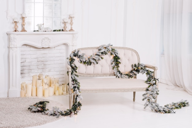 White classic interior with fireplace, sofa and christmas decorations.